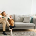 Happy long-lasting marriage. Senior husband and wife hugging, drinking coffee resting on sofa