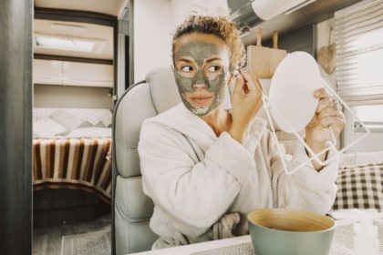 One pretty adult young woman busy in daily skin face care routine using natural green mask