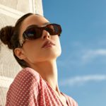 Outdoor portrait of a young beautiful confident woman posing on the street. Model wearing stylish