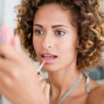 Woman applying make up in mirror